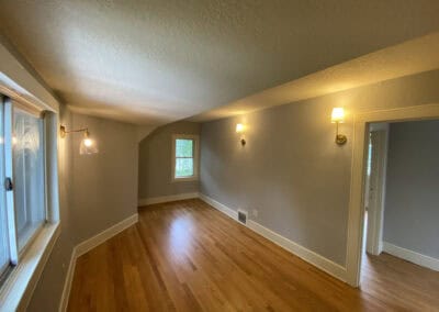 An empty room with wall mounted lights and an electrical outlet