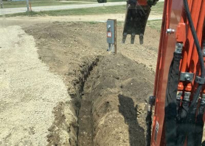 A backhoe, digging a trench for burying electrical wires